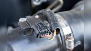 A diagnostic scan showing a P0101 code next to a dirty sensor to illustrate the symptoms of a bad mass air flow sensor in a modern vehicle.