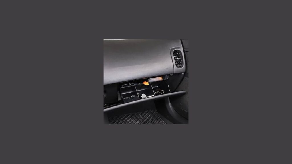 An organized center console tray inside a C6 Corvette interior with natural lighting.