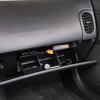 An organized center console tray inside a C6 Corvette interior with natural lighting.