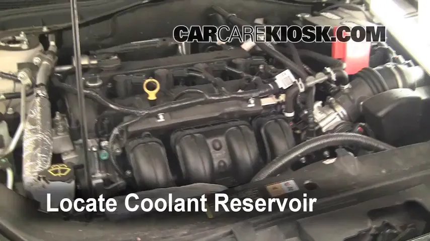 A mechanic pours cooling system radiator stop leak into a Ford Fusion engine.