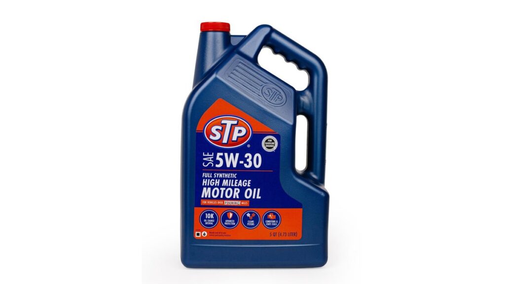 A mechanic pours high mileage engine treatment additive into a Ford Fusion engine.