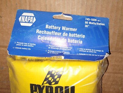 Battery heater blanket resting on a Toyota Corolla engine bay in winter
