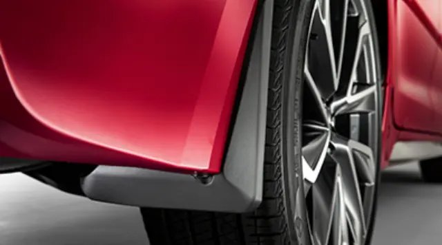 Black mud flaps installed on a silver Toyota Corolla parked on a wet suburban street.