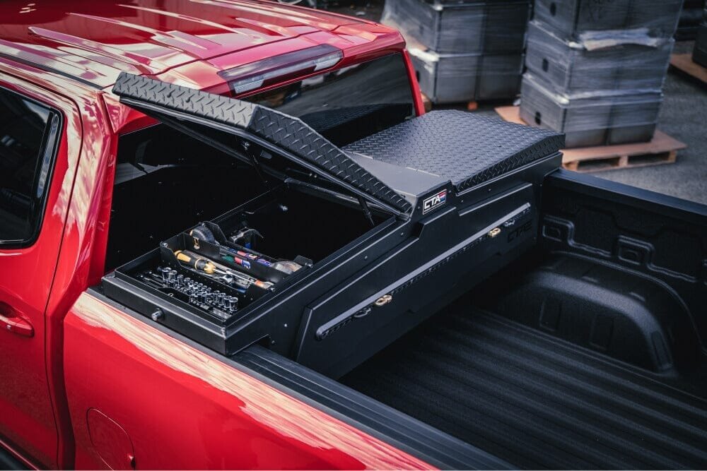 Black pickup truck with bed accessories on a driveway in soft daylight