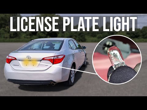 A bright LED light illuminates the rear license plate of a modern Toyota Corolla.