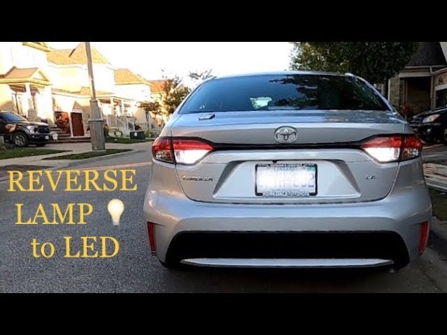 A bright LED reverse light illuminates the rear tail assembly of a Toyota Corolla.