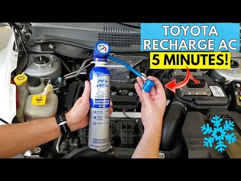 Car AC refrigerant recharge kit with gauge and hose on a garage workbench