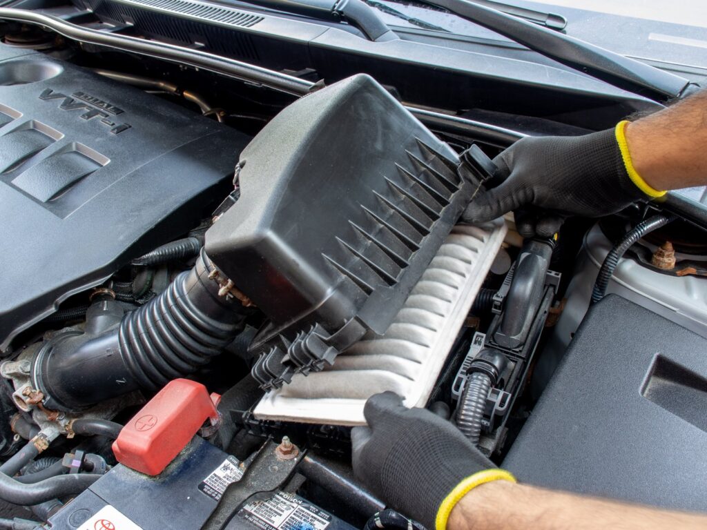 A clean engine air filter for a Toyota Corolla sits on a workshop workbench.