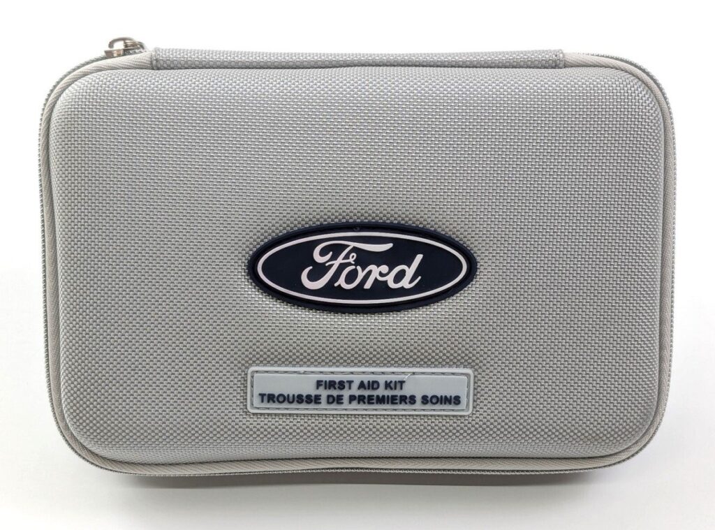 A compact automotive first aid kit placed inside a modern Ford Fusion vehicle.