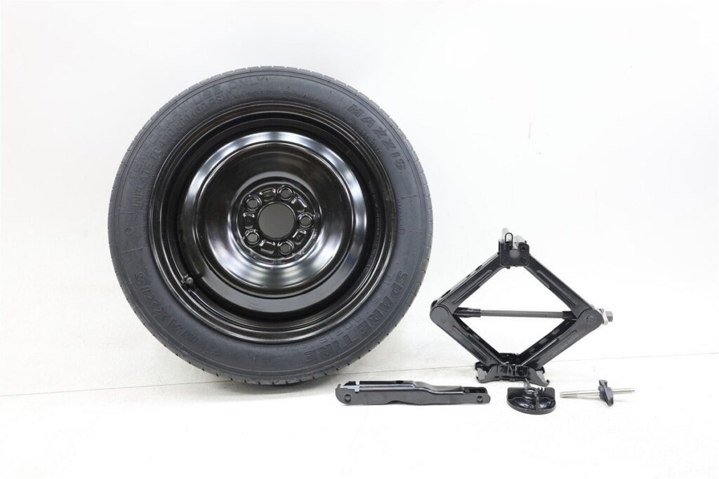 A compact spare tire wheel kit for a Ford Fusion resting on a floor.
