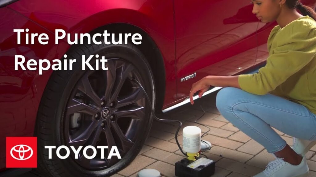 A comprehensive flat tire repair kit for a Toyota Corolla displayed on a garage floor.