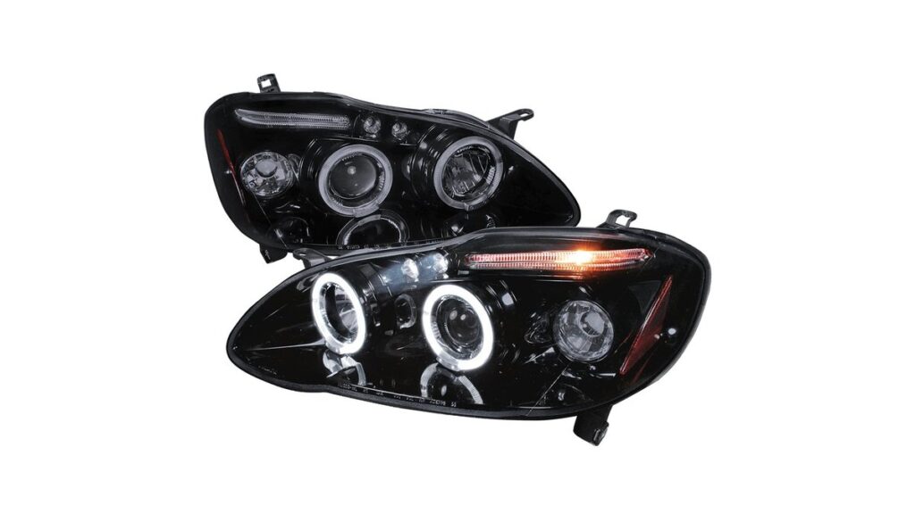 A detailed close-up of a modern projector headlight assembly on a silver Toyota Corolla.
