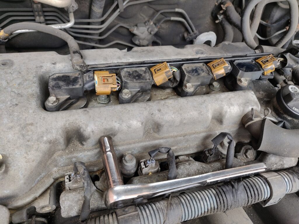 Four new spark plugs arranged neatly on a clean workbench for Toyota Corolla maintenance.