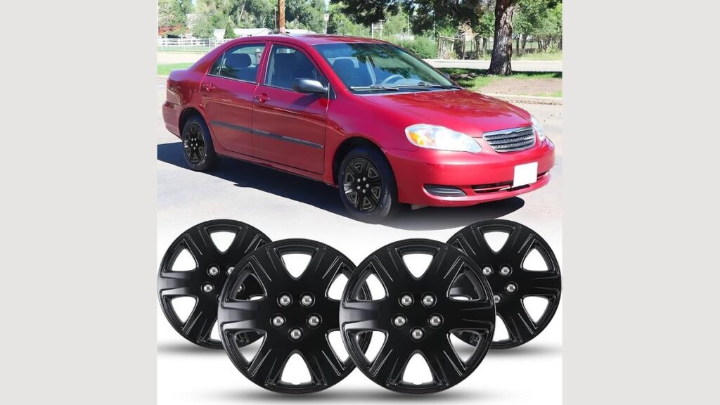 Four silver hubcaps wheel covers for a Toyota Corolla lined up against a garage wall