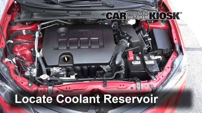 Green engine coolant jug beside an open Toyota Corolla hood in a garage