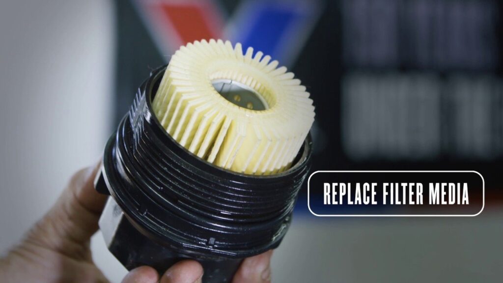 A high-quality replacement oil filter for a Toyota Corolla on a garage workbench.