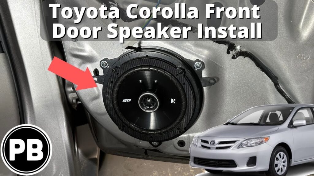 New aftermarket speaker resting on the open door panel of a silver Toyota Corolla.