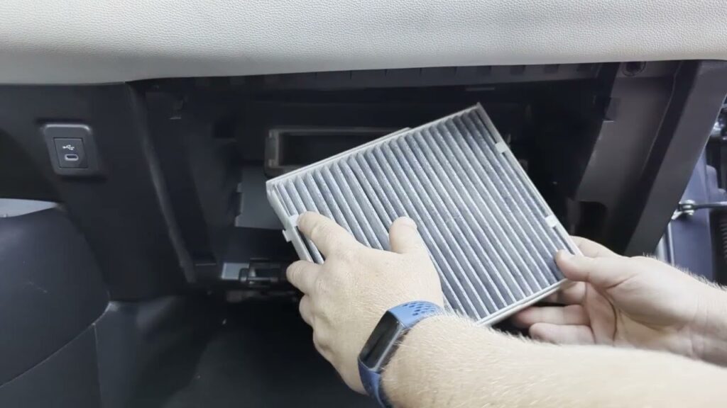 A new cabin air filter for a Toyota Corolla sits inside an open glove box.