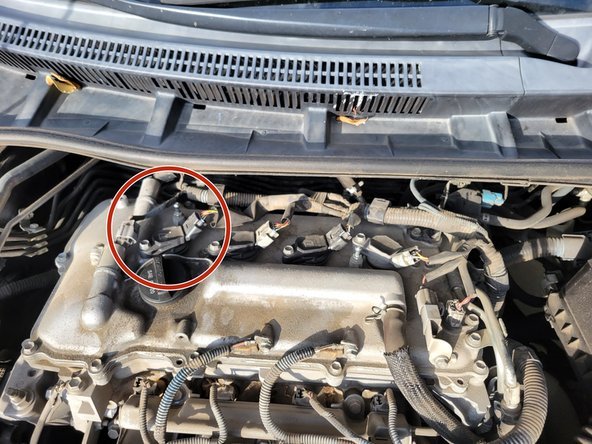 A new ignition coil for a Toyota Corolla sits on a professional workbench.
