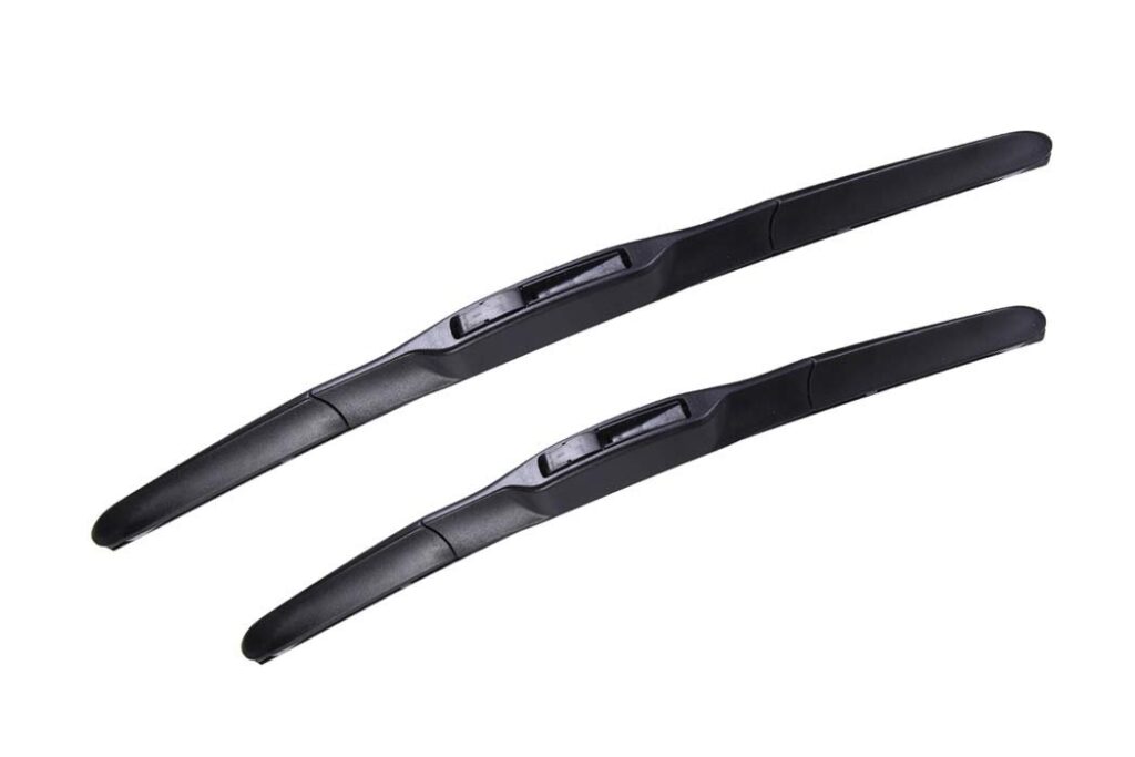 New Toyota Corolla wiper blades on a rain-speckled windshield in soft daylight.