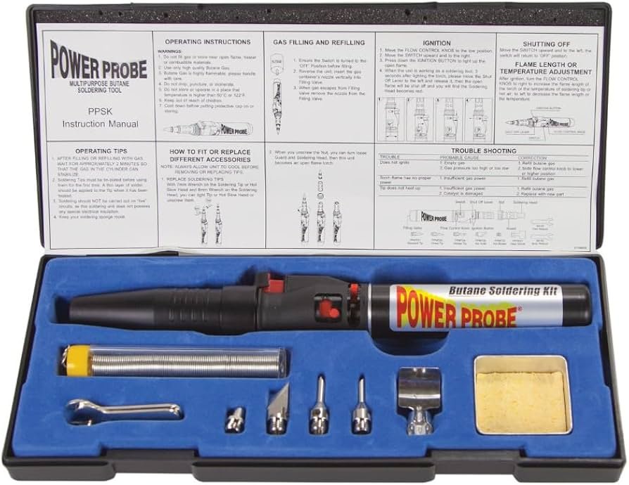 Open automotive soldering kit with iron, solder and heat-shrink tubing on a workbench