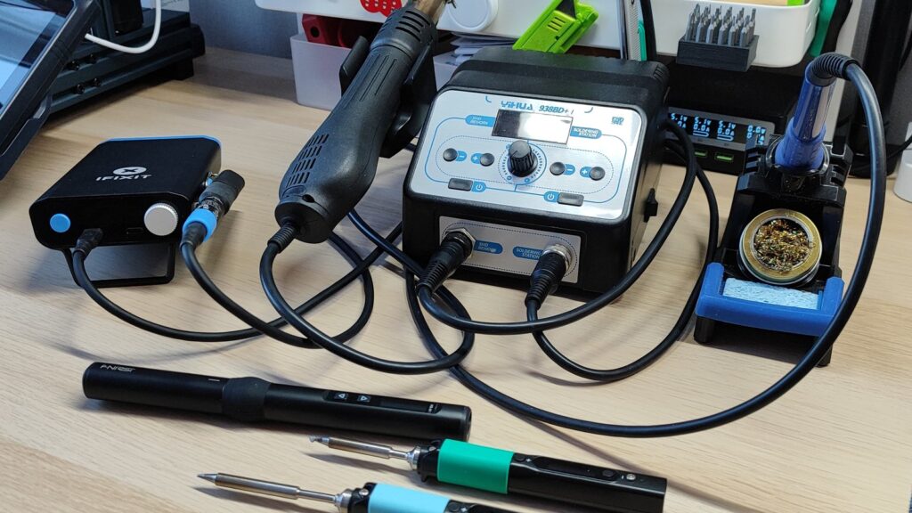 Professional soldering iron and solder wire on an automotive workbench