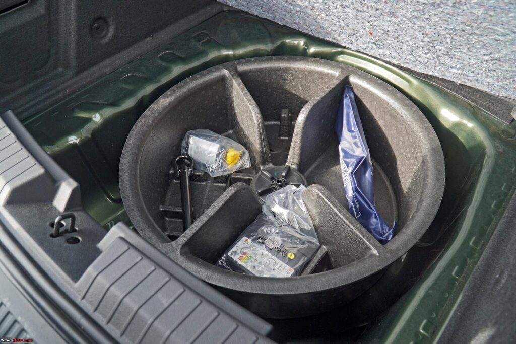 A professional tubeless tire puncture repair kit rests beside a Ford Fusion tire.