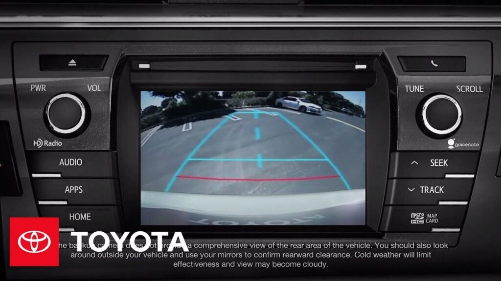 Silver Toyota Corolla showing rear backup camera on a quiet street