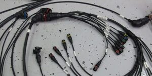 Soldering iron joining a wire on an automotive wiring harness at the workbench