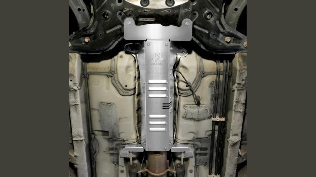 A stainless steel catalytic converter anti-theft shield installed under a Toyota Corolla sedan.